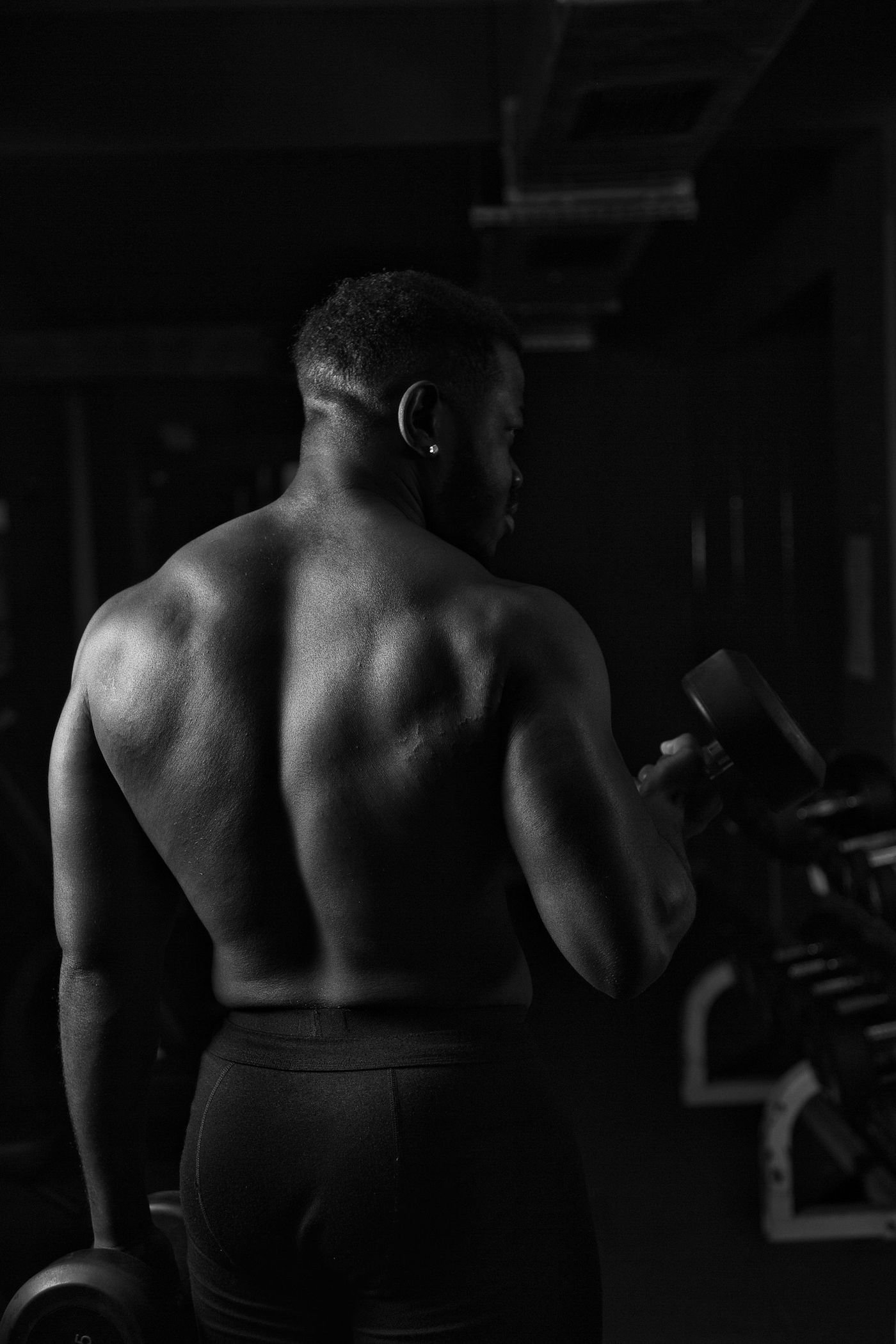 a black man with no shirt prepares for a BBC phone sex call.